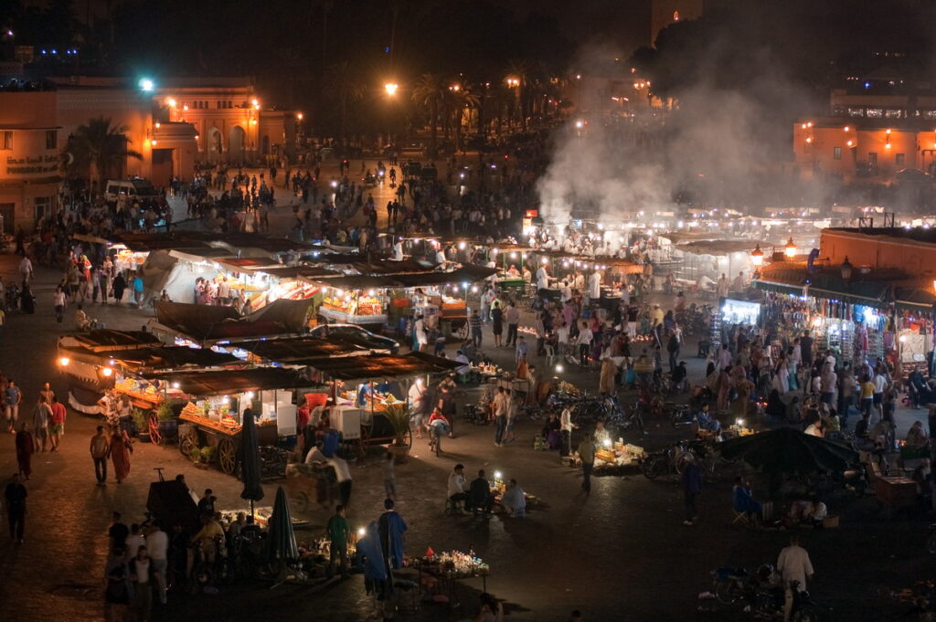 Vibrant night scene at Djemaa el Fna square in Morocco, with illuminated food stalls showcasing the lively and diverse culinary offerings of Moroccan cuisine.