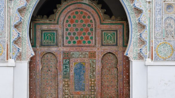 A fountain in the courtyard of the Al-Qarawiyyin Mosque and University in Fez, Morocco. The courtyard is surrounded by traditional Moroccan architecture with intricate tilework and archways. The fountain is the central focal point of the courtyard.