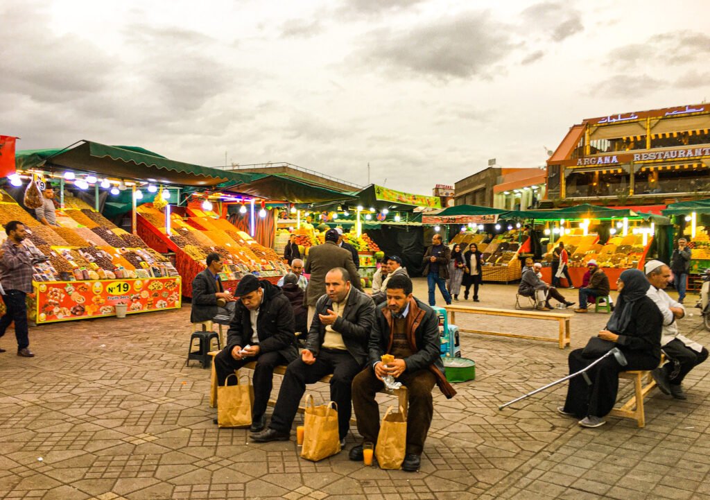 Street Food in Morocco - Locals in the vibrant Old Medina of Marrakech, Morocco, relishing the delectable street food offerings, showcasing the lively culinary culture and gastronomic delights of Morocco