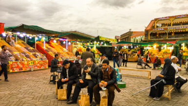 Street Food in Morocco - Locals in the vibrant Old Medina of Marrakech, Morocco, relishing the delectable street food offerings, showcasing the lively culinary culture and gastronomic delights of Morocco