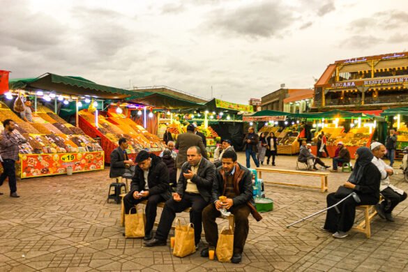 Street Food in Morocco - Locals in the vibrant Old Medina of Marrakech, Morocco, relishing the delectable street food offerings, showcasing the lively culinary culture and gastronomic delights of Morocco