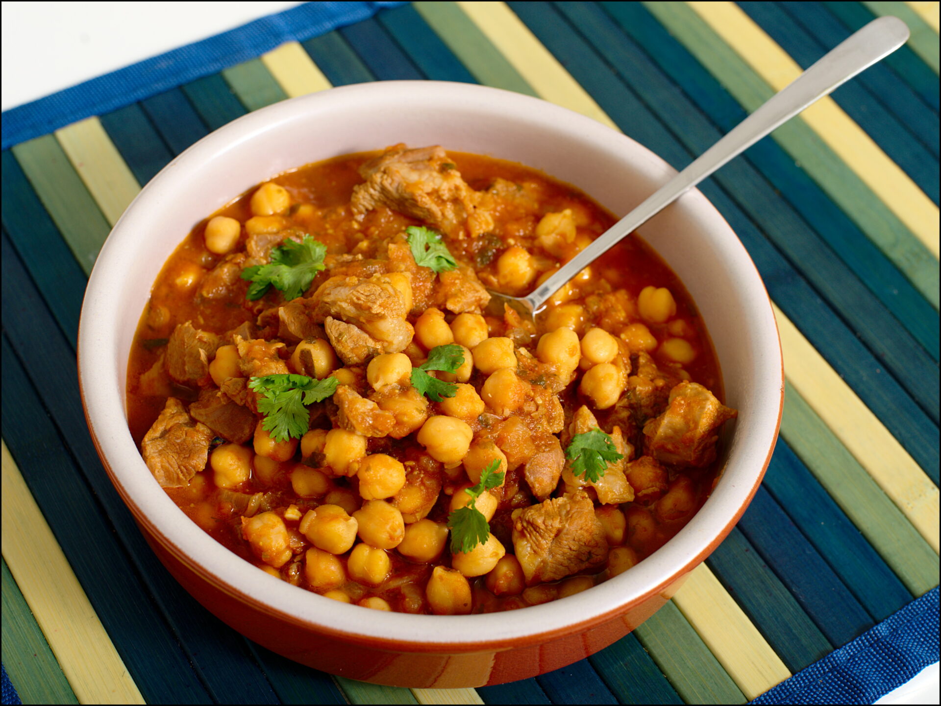 Image of a bowl of traditional Moroccan Harira Soup, with an array of ingredients including chickpeas, lentils, and spices. This image highlights the variety of options available for this dish, including both meat-based and vegetarian versions.