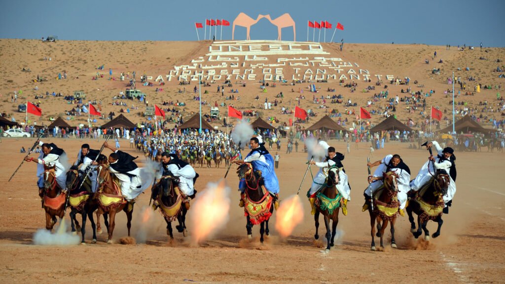 A group of horse riders wearing traditional clothing participating in the Moussem de Tan-Tan 2013 festival in Morocco, demonstrating the traditional equestrian performance known as tbourida.