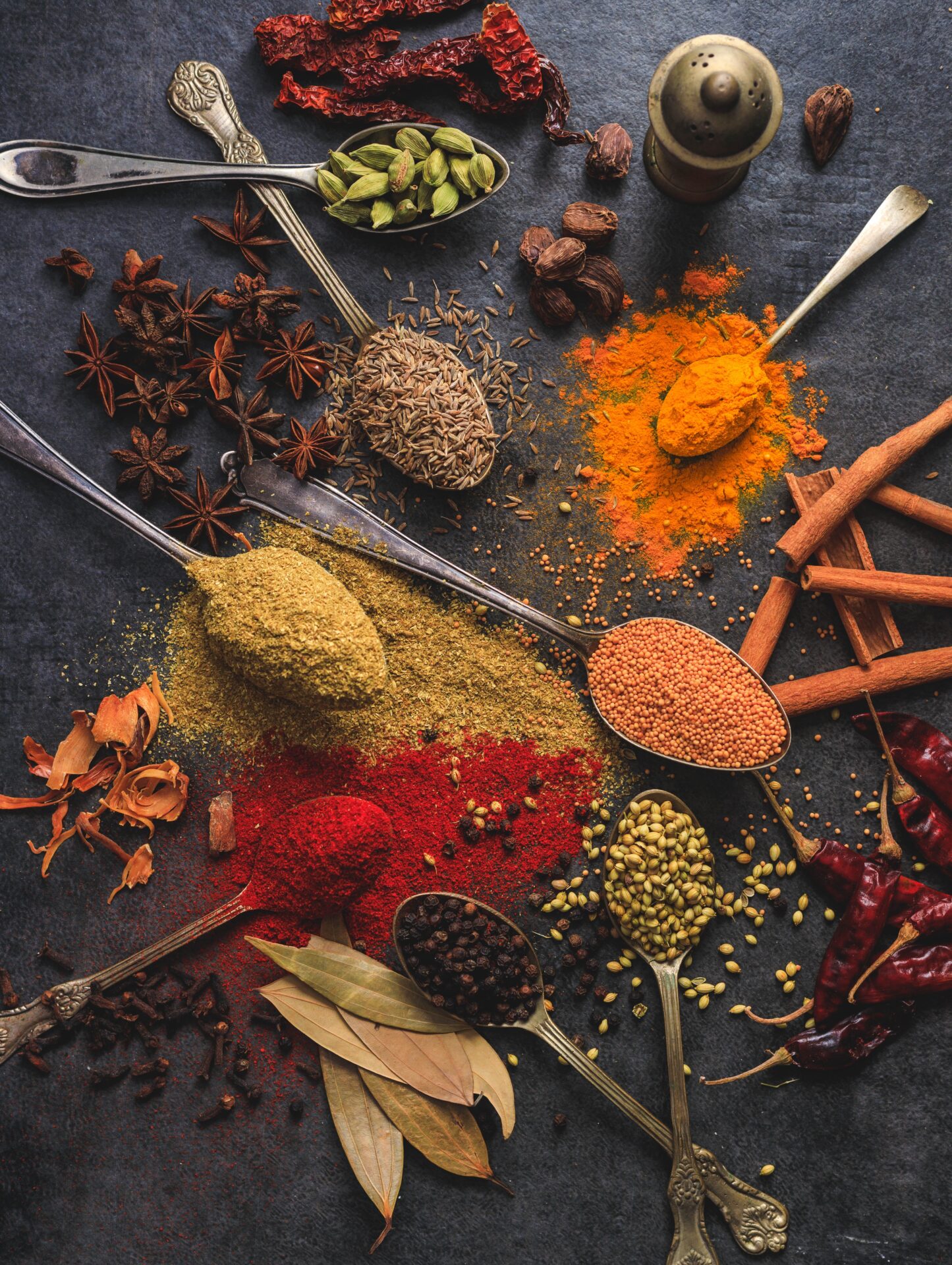 A variety of colorful spices commonly used in Moroccan cuisine, including anise, chili, cumin, pepper, star Anise and turmeric.