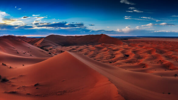 A panoramic view of the Sahara Desert at sunset, showcasing its vast expanse and captivating beauty