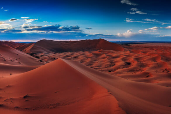 A panoramic view of the Sahara Desert at sunset, showcasing its vast expanse and captivating beauty