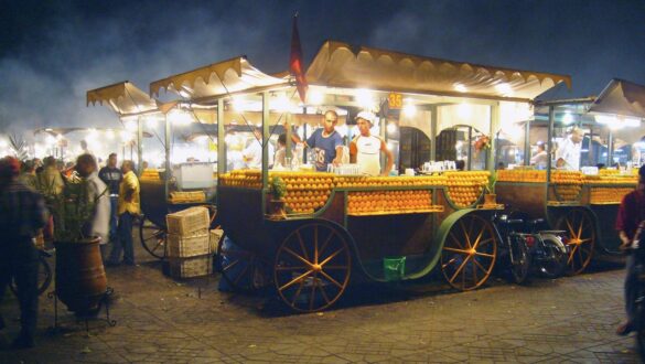 A vibrant scene at Jamaa el Fna square in Marrakech, Morocco, featuring colorful food stalls, traditional Moroccan cuisine, and bustling activity under warm evening lights.